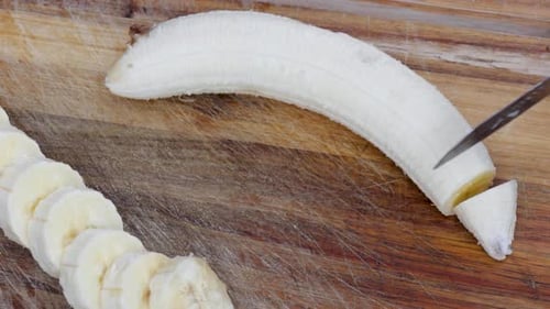 Video cutting up a banana in even slices.