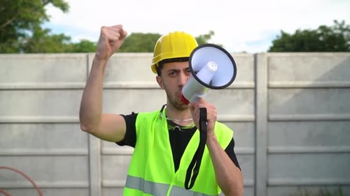 Construction Worker Shouting into Megaphone Outdoors