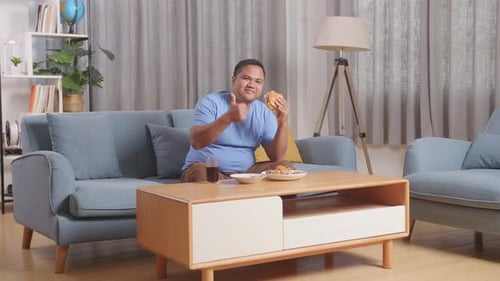 Man Eats Burger and Gives Thumbs Up