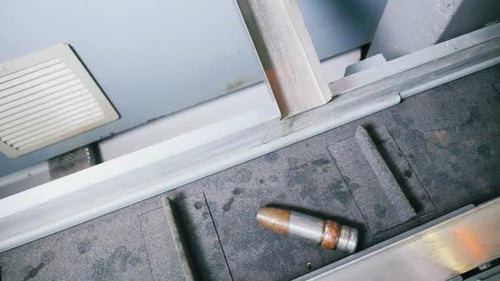 Bullets Shells Slide Along Gutter to Fall Down Onto Conveyor