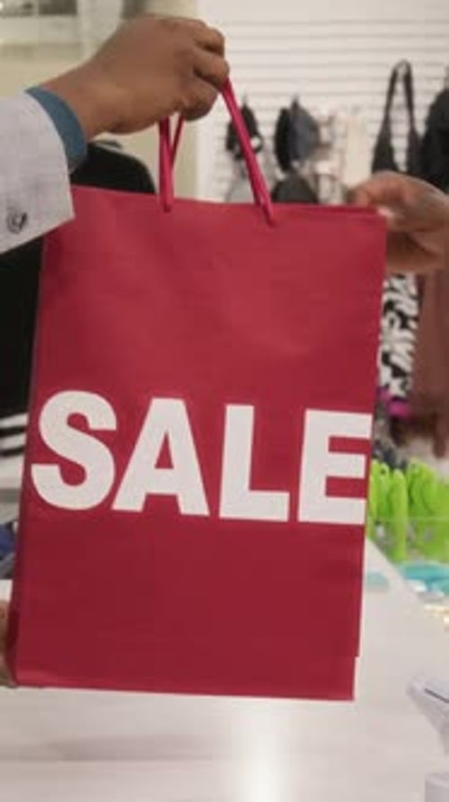Close Up of Hands Exchanging Shopping Bag