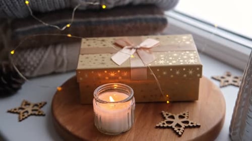 Candle and Gift by Window at Christmas