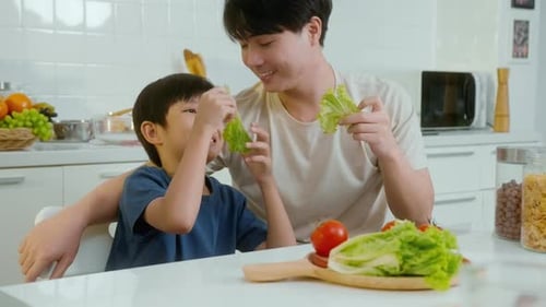 Father and Son Play with Lettuce in Kitchen
