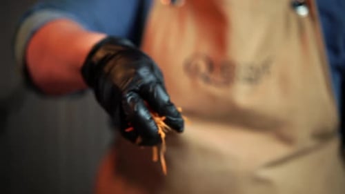 Koch mit Handschuhen, Salat mit Karotten würzen, Zeitlupe