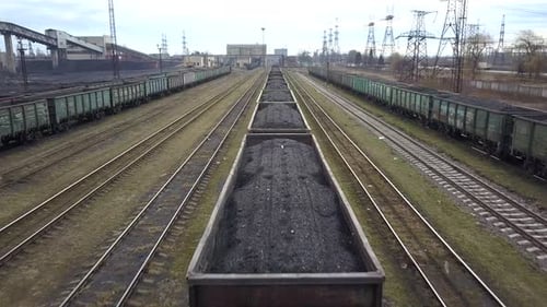 Long Row of Train Cargo Cars Loaded Full with Fossil Fuel Coal