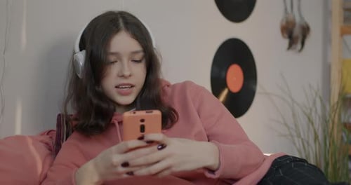 Teenage Girl Relaxing with Mobile Phone and Music
