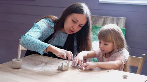 Creating Clay Figures in a Cozy Studio with a Young Child