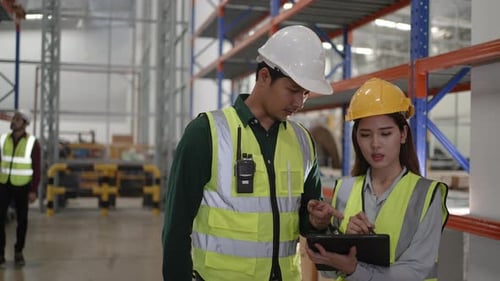 Blue collar workers are working at warehouse.