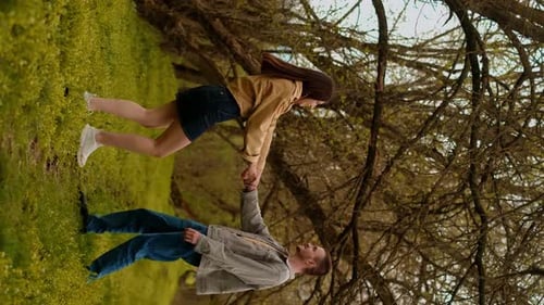 A young couple holding hands run through the forest, embodying an active lifestyle and tourism. Spor