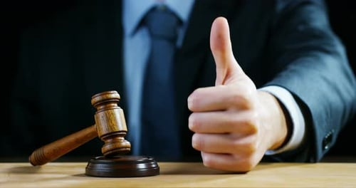 Gavel with Thumbs Up Gesture in Courtroom