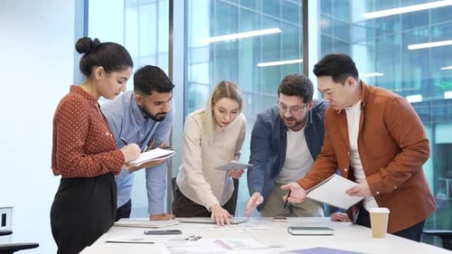 Group of business people communicate at meeting in office. Team of professionals discussing startup