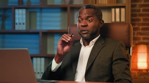 African American Businessman Sitting in Home Office Talking on Video Call on Laptop Male Teacher