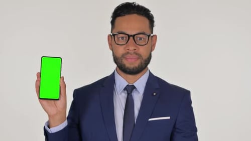 Hispanic Businessman Holding Smartphone with Green Chroma Key Screen on White Background