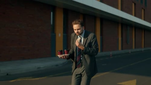 Young Office Man Eating Sandwich and Rushing Through City Street
