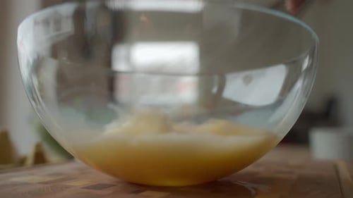 Whisking Eggs in Glass Bowl on Kitchen Counter During Home Cooking