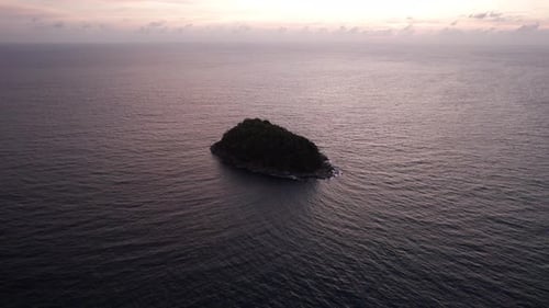 A Tropical Island at Sunset in the Middle of Ocean