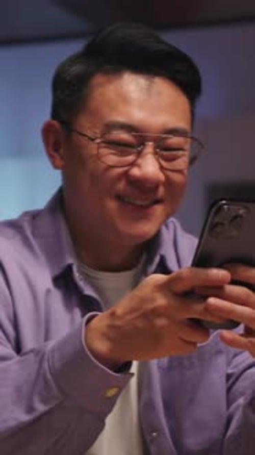 Young Adult Man Using a Smartphone Indoors