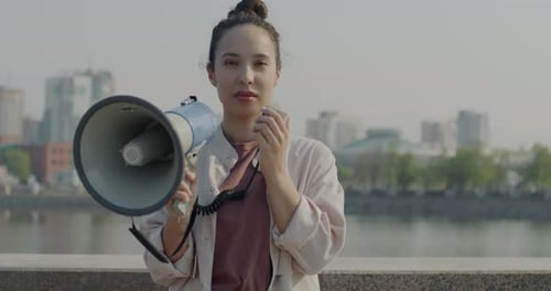 Woman Holding a Megaphone and Speaking Outdoors