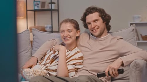 Couple Watching TV Together on Couch at Home