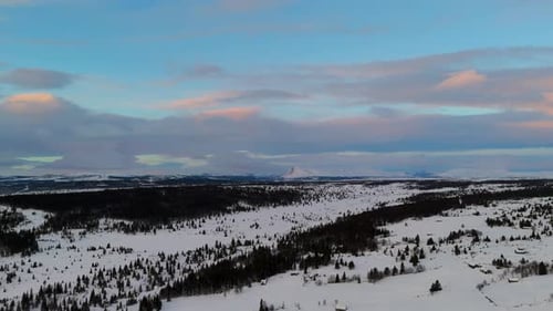 Aerial view of a snow covered village in a valley surrounded by mountains. Winter wonderland scenery