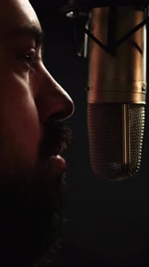 Vertical 4k, Profile of Man With Beard Talking in Front of Professional Studio Microphone