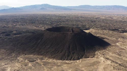 Luftaufnahme des Amboy-Kraters, eines ruhenden Aschekegelvulkans, der sich über dem Lavafeldgestein b erhebt