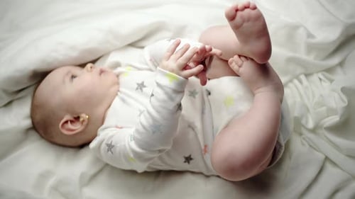 Adorable Infant Lying on Blanket Wearing Star Onesie