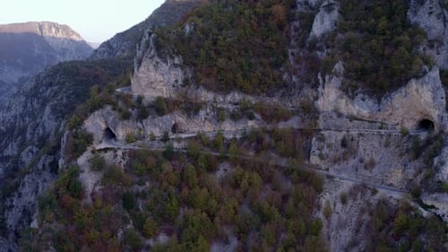 Aerial view of mountain road winding through forest and cliffs, Montenegro.