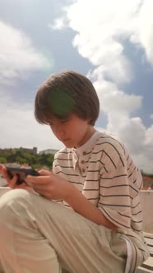 Teen Using Smartphone Outdoors in Urban Setting