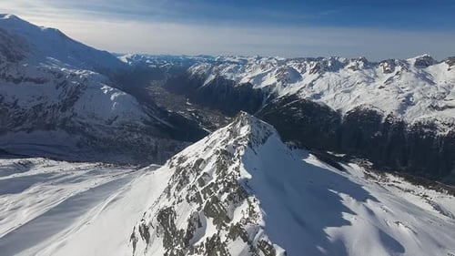 An expansive aerial view over a stunning alpine landscape, showcasing a sharp mountain ridge leading