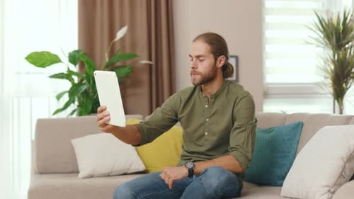 Close Up Man Using Tablet Computer Having Online Conversation with His Colleague Friend Sitting on