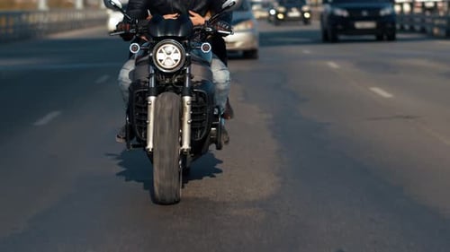 Closeup Front View of Young Bikers on Riding Motorcycle in Urban Background