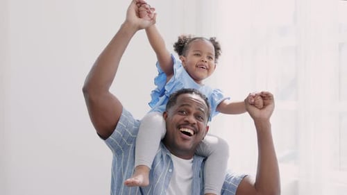 Slow motion happy funny small girl sitting on father shoulder playing piggyback ride child.