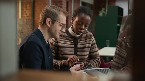 Colleagues Collaborate Using Tablet in Modern Workplace
