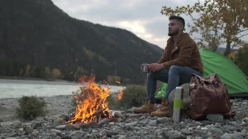 Hiker Tourist Traveler Man with Backpack Mountain Camping Fire Firewood Camp Tent Traveling Hiking