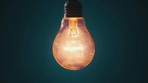 Vintage Lamp on Wire Glows and Flickers on Dark Blue Background