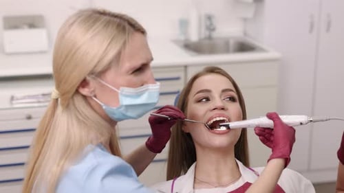 Dentist Examining Young Woman in Clinic