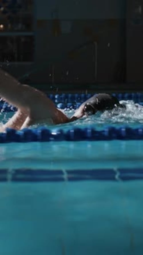 Vertical of Male Athlete Swimming Race in Pool