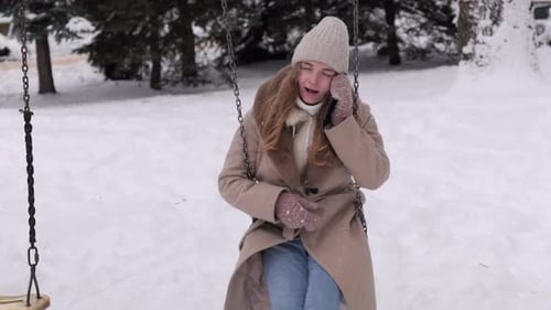 Woman on Swing Talking on Phone in Winter Park