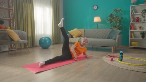 Senior Woman Doing Leg Lifts on a Yoga Mat