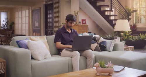 Entrepreneur indien utilisant un ordinateur portable pour le travail à distance, les études en ligne ou des projets indépendants dans le confort