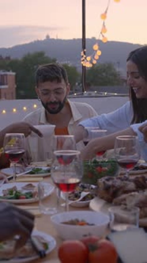 Reunion of Diverse Happy Friends Eating and Drinking Sitting in a Table in a Rooftop Terrace