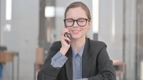 Happy Woman Speaks on Phone in Modern Office