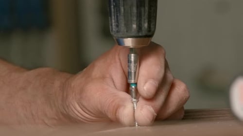 Man Drilling Screw into Wood with Power Drill