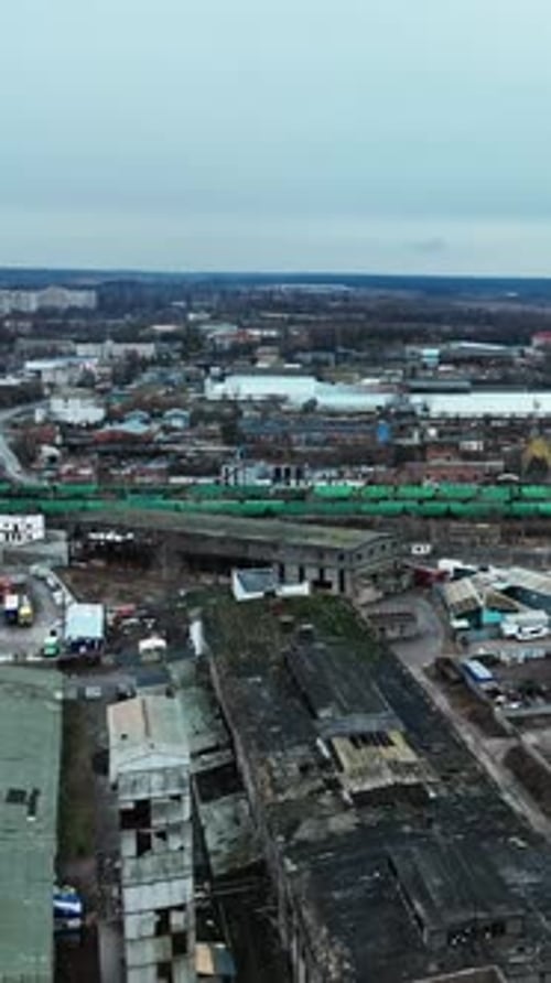 Huge industrial territory abandoned long ago. Aerial view of old ruined warehouses near railways