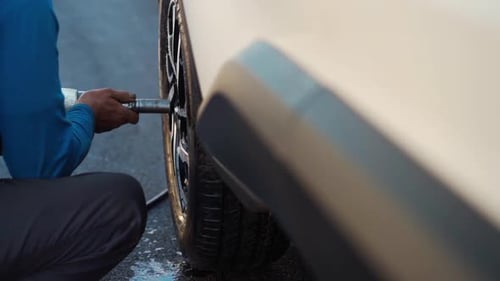 Mechanic Removing Tire Lug Nuts with Air Gun