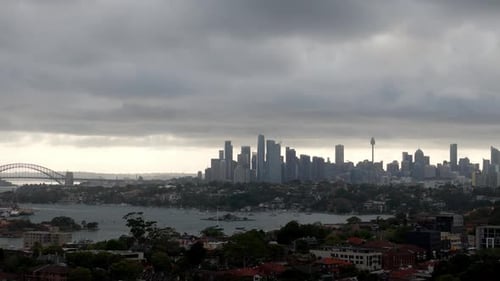 Overcast Skyline View of a Metropolitan City with Iconic Bridge and Tower: A Blend of Urban Architec
