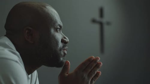 Faithful Man Holding Hands Together and Praying in Church
