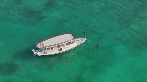 Aerial view of white boat in turquoise water, Maldives.