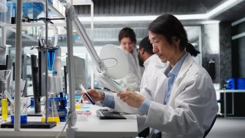 Un professionnel de laboratoire examine un échantillon de tube à essai sous un éclairage contrôlé